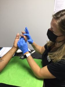 A doctor checking a patient fingers.