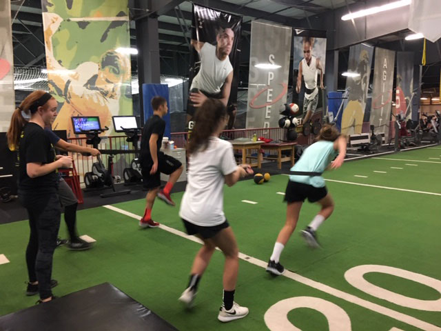 Boys and girls practicing running at a gym